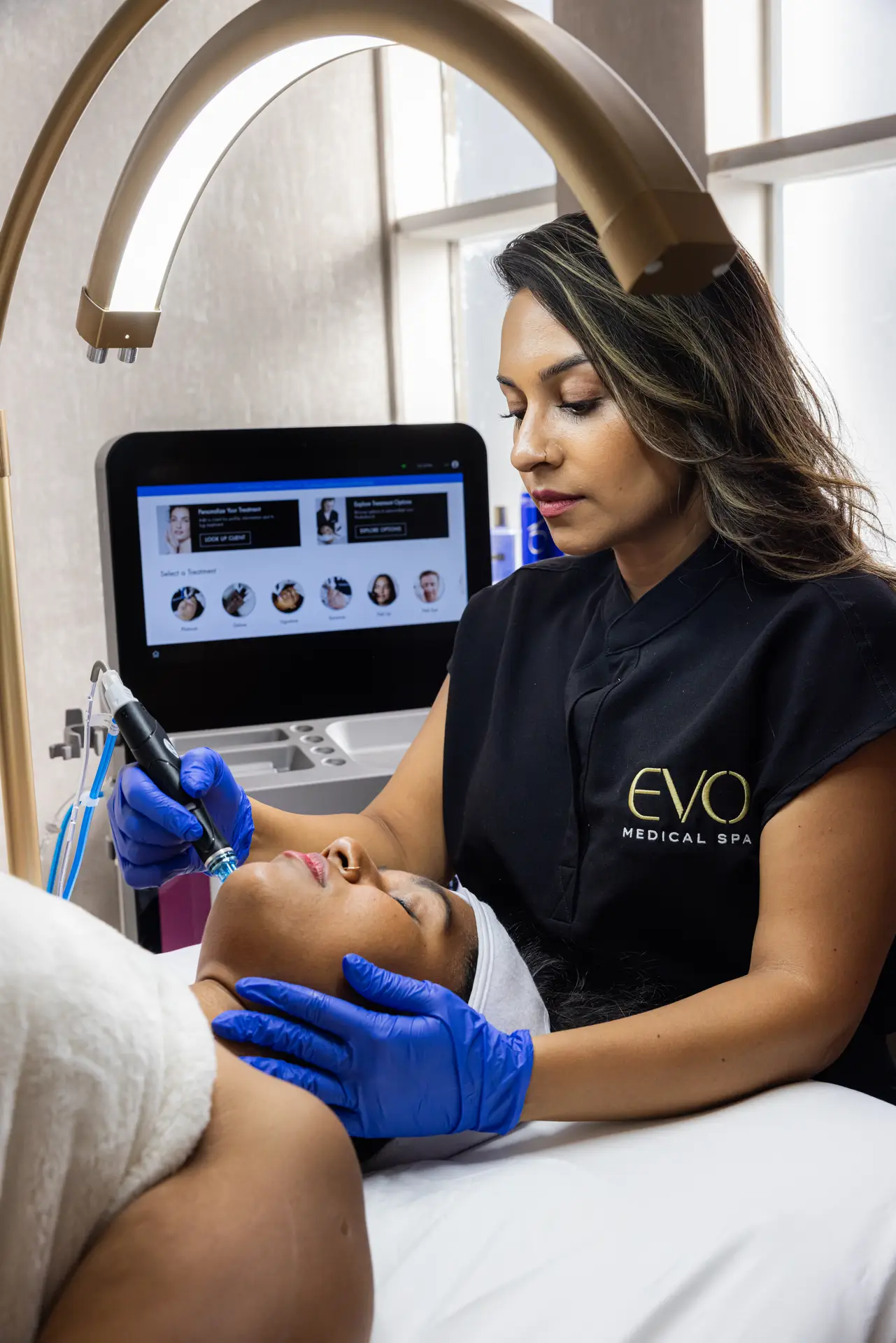 A licensed provider performing a facial treatment at EVO