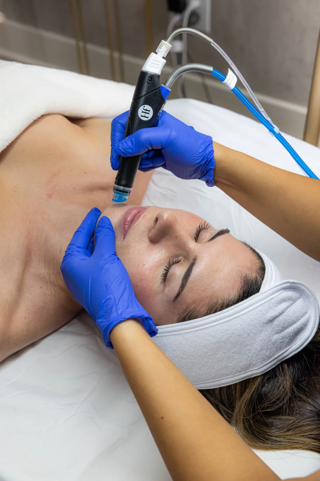A provider using a HydraFacial wand on a client’s face
